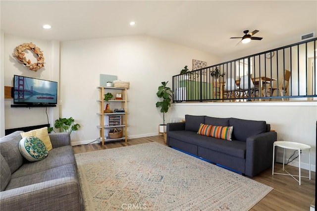 living room featuring ceiling fan, wood-type flooring, and lofted ceiling