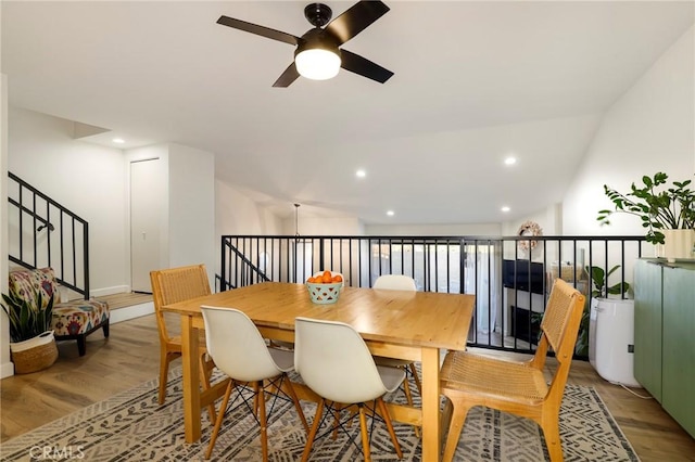 dining room featuring light hardwood / wood-style flooring, vaulted ceiling, and ceiling fan