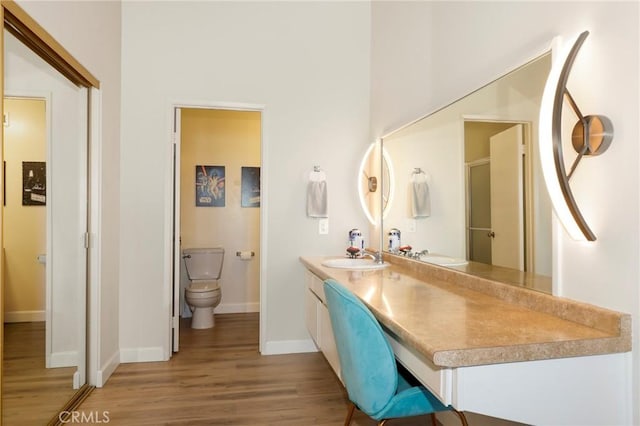 bathroom with hardwood / wood-style floors, toilet, and vanity