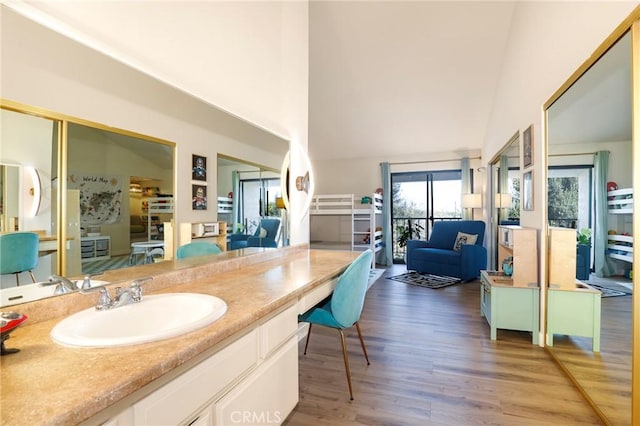 bathroom with sink, wood-type flooring, and lofted ceiling