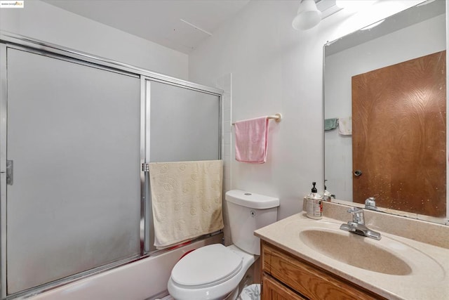 full bathroom with combined bath / shower with glass door, vanity, and toilet