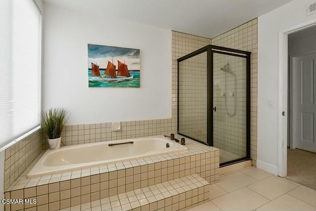 bathroom with a wealth of natural light, tile patterned floors, and independent shower and bath