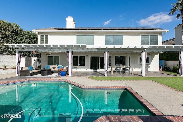 back of property with a patio area, an outdoor living space, solar panels, and a pergola