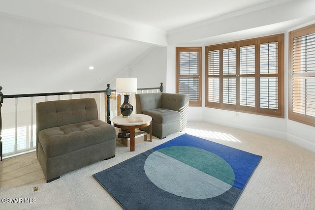 living area with lofted ceiling with beams and carpet flooring