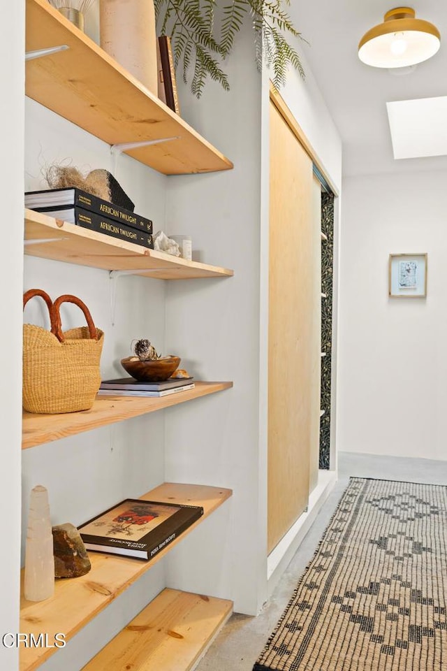 hall with concrete floors and a skylight