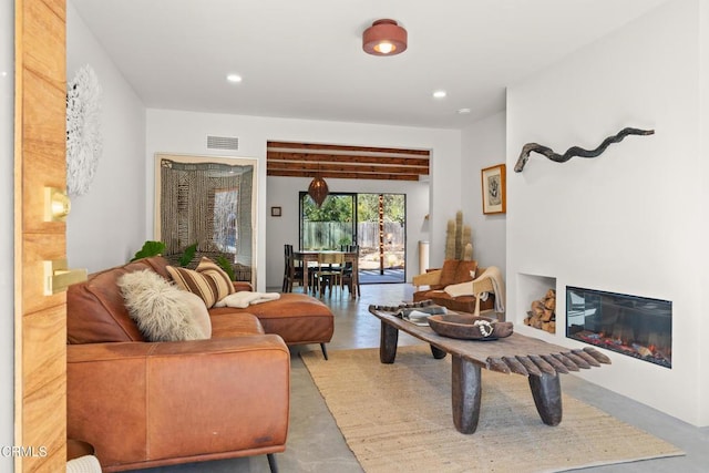 living room featuring beamed ceiling and concrete flooring