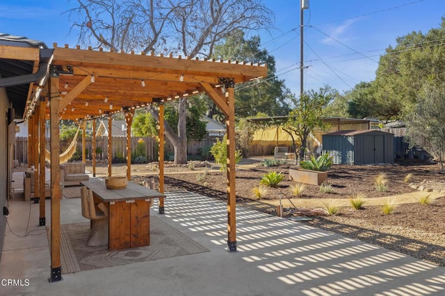 view of patio / terrace with an outbuilding, a storage unit, a fenced backyard, and a pergola