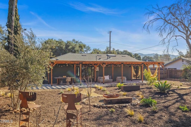 rear view of house featuring an outdoor fire pit, a patio area, fence, and a pergola