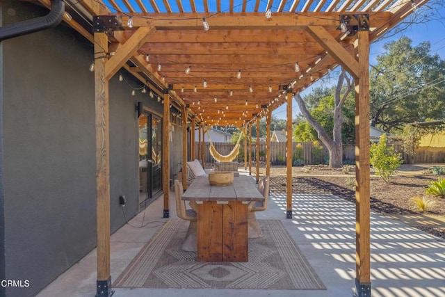 view of patio featuring outdoor dining area, fence, and a pergola