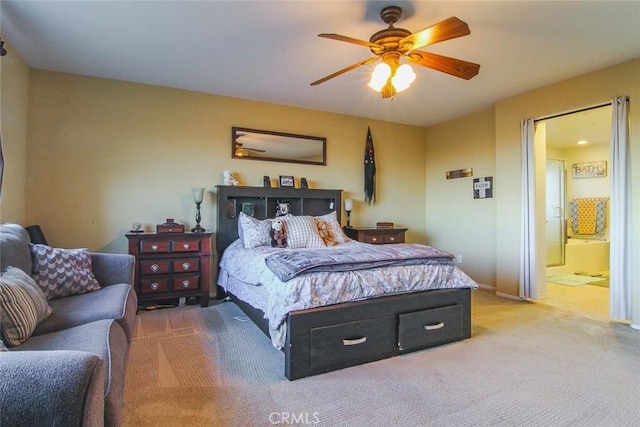 bedroom with ceiling fan, light carpet, and ensuite bath