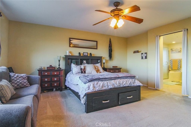 bedroom featuring ensuite bath, light colored carpet, and ceiling fan
