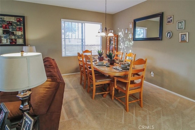 dining space with a chandelier and carpet flooring