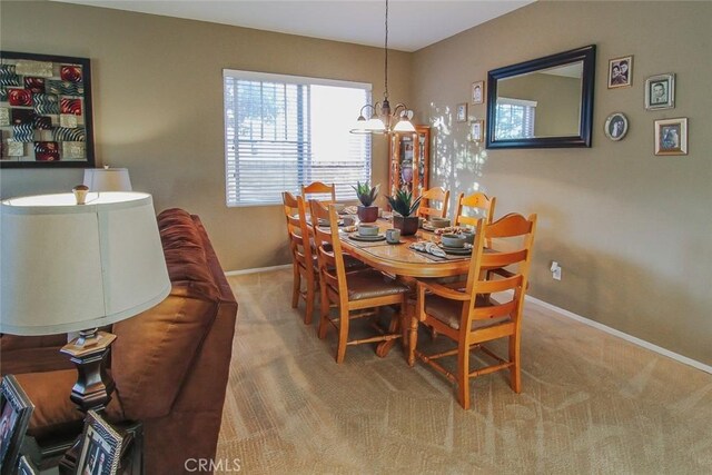 carpeted dining space featuring a chandelier