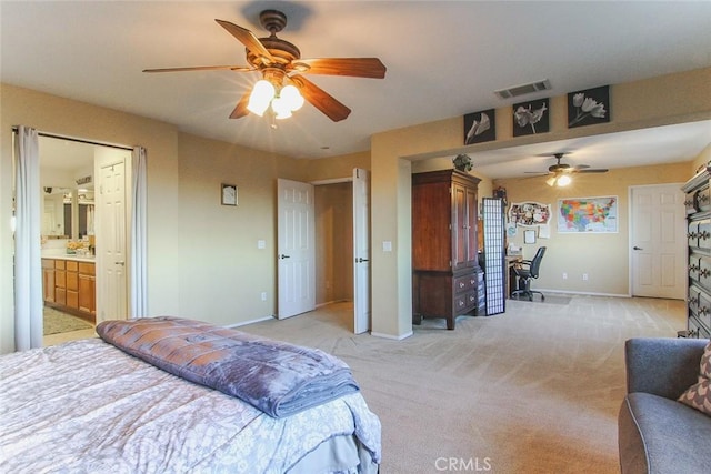 bedroom with ceiling fan, ensuite bath, and light carpet