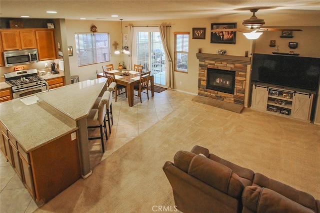 kitchen with light tile patterned flooring, appliances with stainless steel finishes, a center island, and a kitchen bar