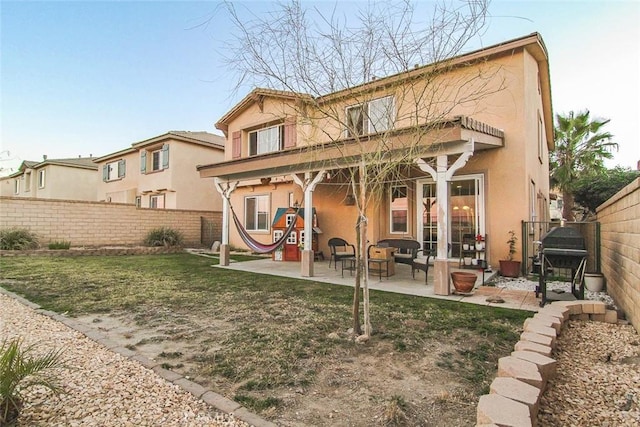 rear view of property featuring a patio and a lawn