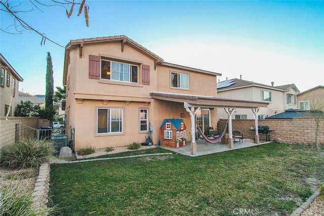 rear view of property with a patio area, cooling unit, and a lawn