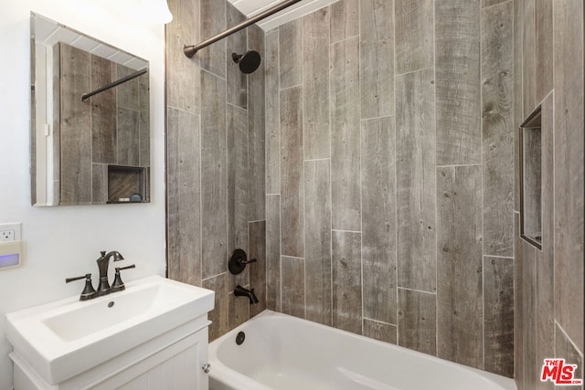 bathroom featuring tiled shower / bath combo and vanity