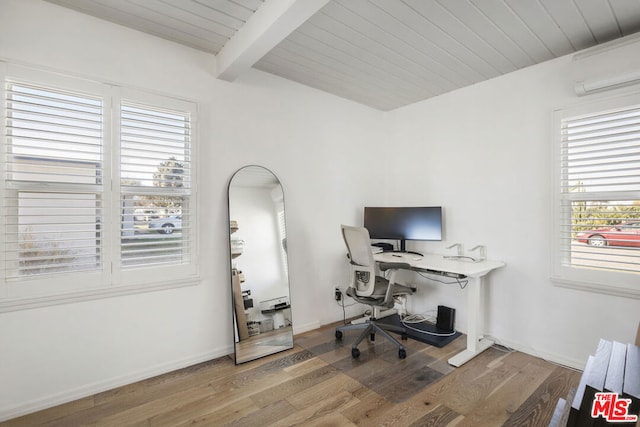 office space featuring hardwood / wood-style flooring, plenty of natural light, beam ceiling, and a wall mounted air conditioner