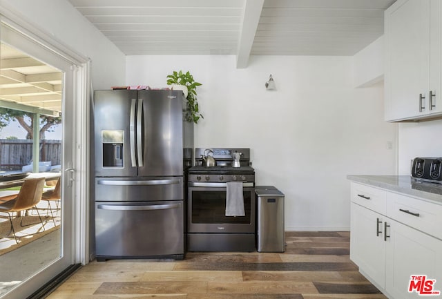 kitchen with white cabinetry, stainless steel appliances, light hardwood / wood-style flooring, light stone counters, and beamed ceiling