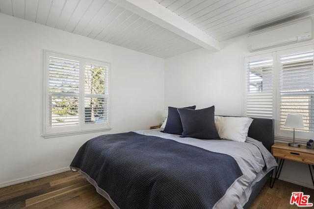 bedroom featuring dark wood-type flooring, beam ceiling, and an AC wall unit