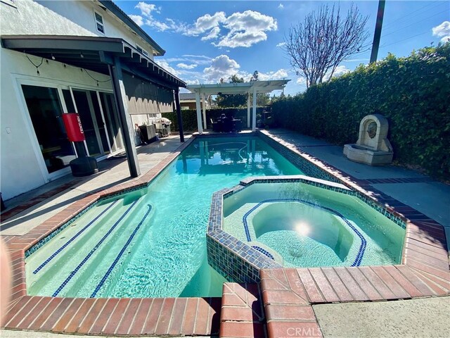 view of swimming pool with an in ground hot tub and a pergola