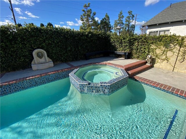 view of pool with an in ground hot tub