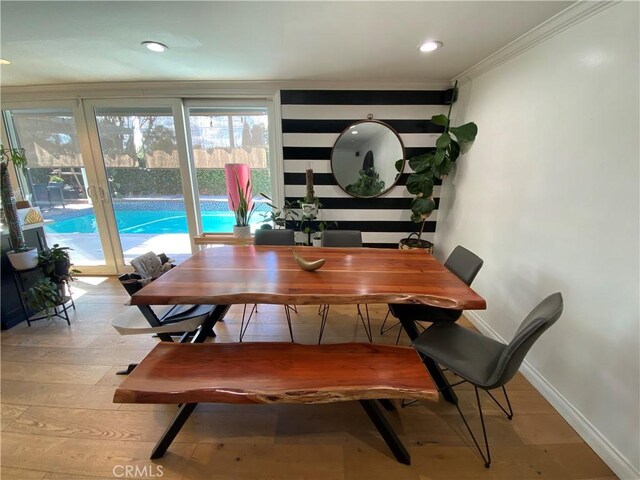 dining area with crown molding and light hardwood / wood-style flooring