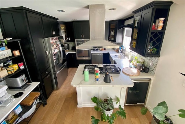 kitchen with appliances with stainless steel finishes, light hardwood / wood-style floors, sink, and decorative backsplash