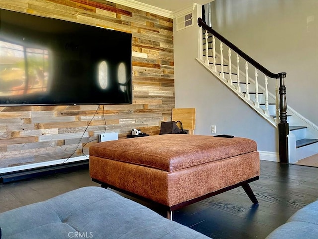 living room with crown molding, dark hardwood / wood-style floors, and wood walls