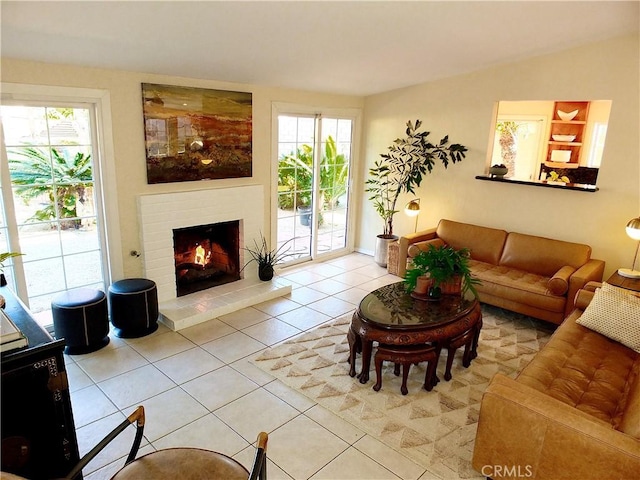 living room featuring vaulted ceiling, a brick fireplace, and light tile patterned floors