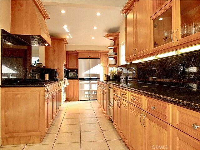 kitchen with custom exhaust hood, sink, black appliances, and dark stone counters