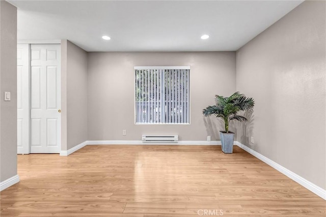 spare room featuring light hardwood / wood-style floors and a baseboard heating unit