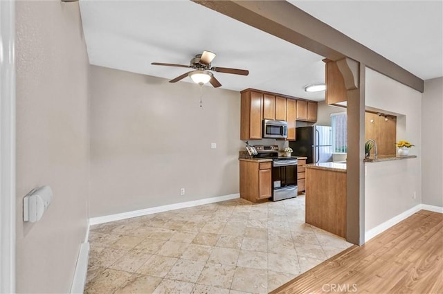 kitchen featuring ceiling fan, stainless steel appliances, and sink