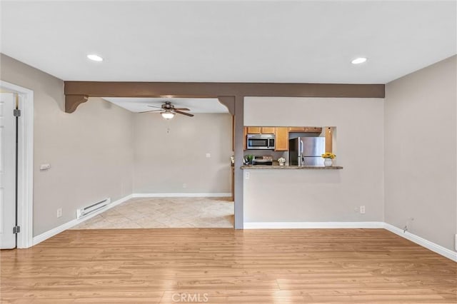 unfurnished living room with light hardwood / wood-style flooring, ceiling fan, and baseboard heating