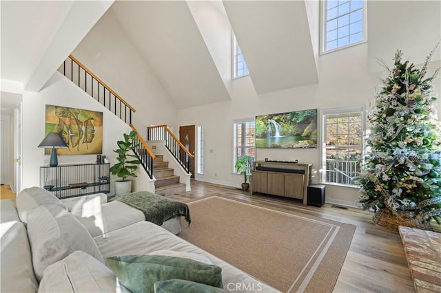 living room with a towering ceiling and light hardwood / wood-style floors