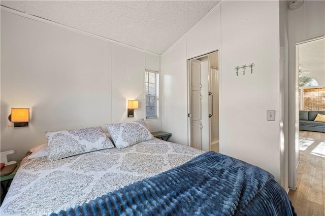 bedroom with vaulted ceiling and a textured ceiling