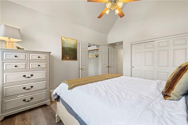 bedroom with a closet, dark hardwood / wood-style flooring, high vaulted ceiling, and ceiling fan