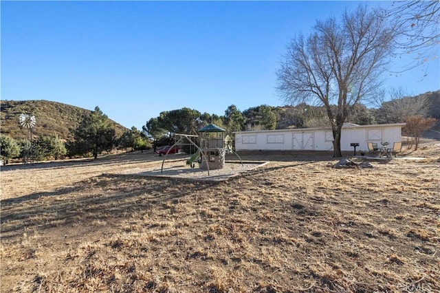 view of yard with a mountain view and a playground