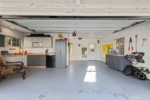 garage featuring sink, refrigerator, and a garage door opener