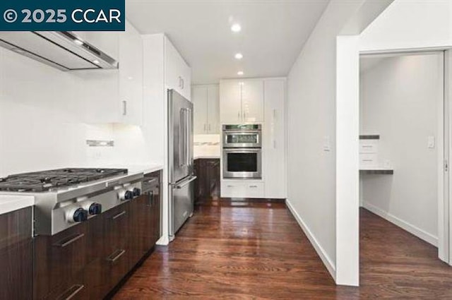 kitchen featuring dark wood-type flooring, stainless steel appliances, ventilation hood, and white cabinets