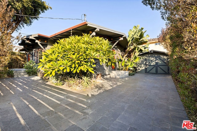 obstructed view of property with a garage and an outdoor structure