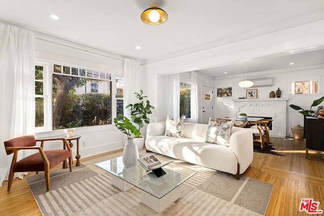 living room with an AC wall unit, light hardwood / wood-style flooring, and a fireplace