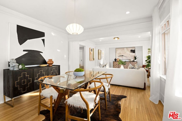 dining space with light hardwood / wood-style floors and crown molding