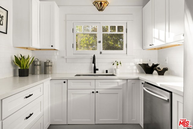 kitchen featuring decorative backsplash, sink, and white cabinets