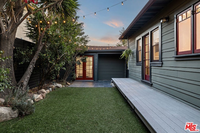 yard at dusk featuring a wooden deck