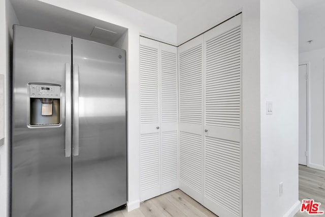 room details featuring light wood-type flooring and stainless steel refrigerator with ice dispenser