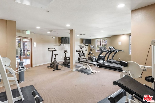 workout area featuring light carpet and french doors