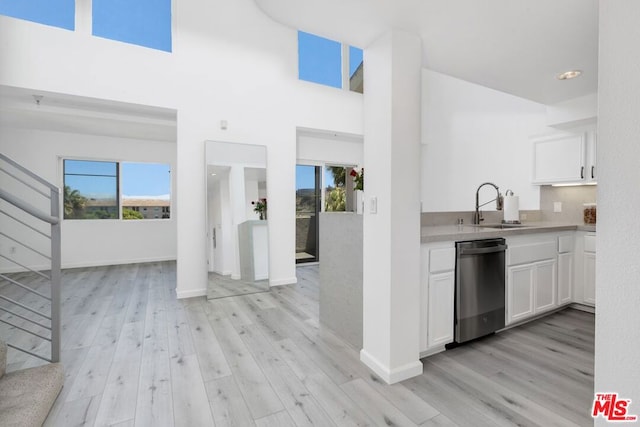 kitchen with light hardwood / wood-style floors, sink, white cabinetry, and dishwasher