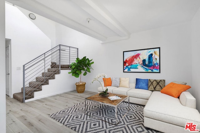 living room featuring beam ceiling and light hardwood / wood-style floors